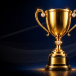 Gold trophy on a dark blue stage with shimmering reflections and tiny sparks at the base in a victory scene.