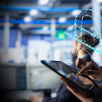 Professional using a tablet, with a glowing holographic padlock signifying cybersecurity.